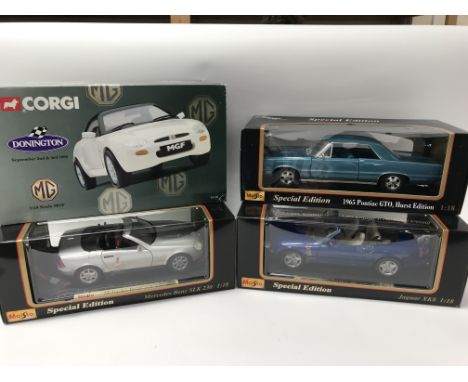 A collection of boxed 1:18 scale diecast vehicles including Corgi MGF, Maisto special editions, 1965 Pontiac GTO, Jaguar XK8 