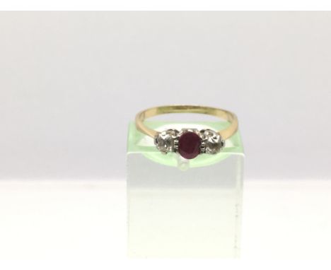 A gold ring set with a central ruby and two diamonds, approx 1.9g and approx size L.