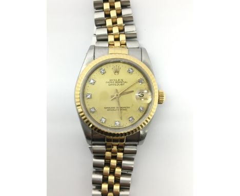 A midi Rolex Datejust wristwatch. The gold dial is decorated with square diamond numerals and a magnified date aperture, with
