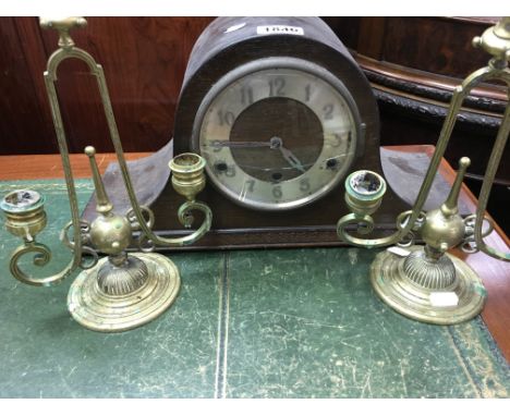 A pair of brass classical candle sticks and a oak mantle clock