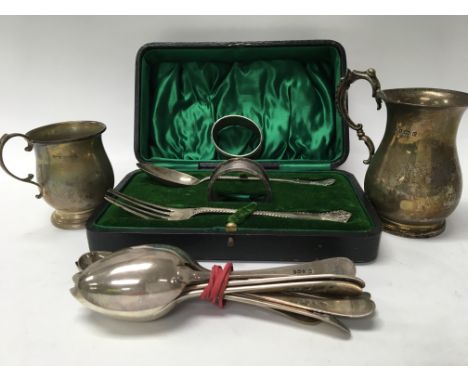 A collection of silver comprising two mugs cased fork and spoon two napkin rings and single silver spoons