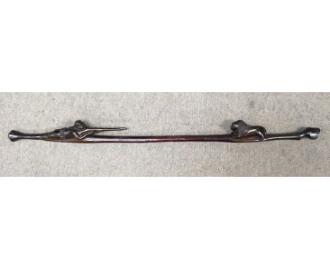 An unusual carved wood walking stick or beater of hunting interest, showing a hunter shooting a lion. Length approx 98cm.