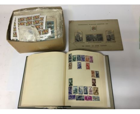 A collection of interesting stamp sheets and a stamp album of world stamps. Also included is a commemorative silk piece for t