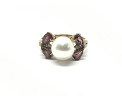 A ladies 9ct gold ring set with a central pearl flanked by a small diamond either side and two pear cut garnets either side. 