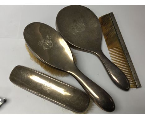 A silver backed dressing table mirror with matching brushes and comb Birmingham hallmarks.