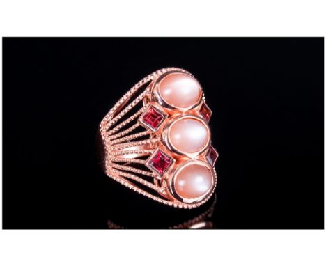 Peach Moonstone and Rhodolite Garnet Ring, three oval cut peach moonstone cabochons, running along the finger, with four squa