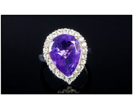 Amethyst and Peridot Pear Cut Ring, the single pear cut purple amethyst, measuring 6.15cts, of good colour, enhanced by a fra