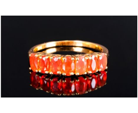 Fire Opal Half Eternity Ring, comprising seven oval cut fire opals, four claw set, closely together, in a single row across t