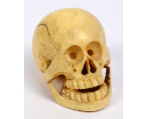 A Japanese Meiji period carved ivory netsuke in the form of a skull, height 3.2cm.
