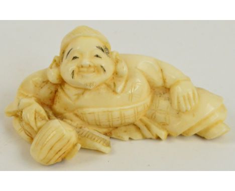 A Japanese Meiji period carved ivory netsuke modelled as a seated man, length 6.5cm.
