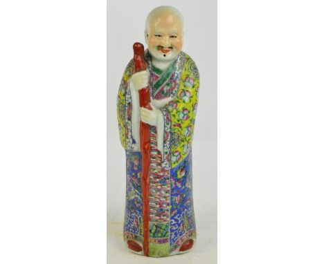 A large early 20th century Chinese porcelain figure, his robe painted in enamels with fruit, insects and shou characters, on 