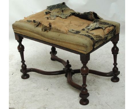 A Continental walnut stool, the padded top above turned and block supports united by a central shaped stretcher. CONDITION RE