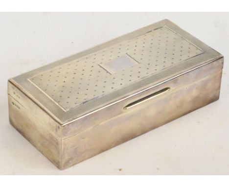 A George V hallmarked silver three division cigarette box with engine turned decoration to the lid and central vacant cartouc