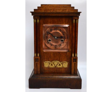 A c.1900 oak Arts and Crafts fourteen day mantel clock, the stepped rectangular case set with copper dial with Arabic numeral