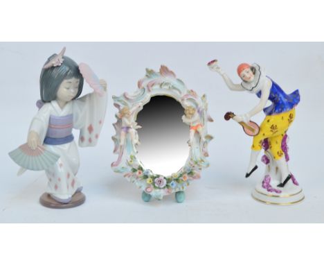 A late 19th century Sitzendorf porcelain mirror with scroll decorated oval frame flanked by two cherubs above floral encruste