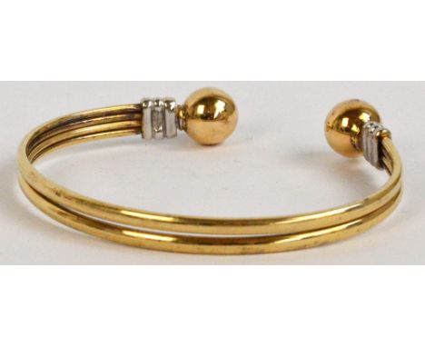 A 9ct two tone gold bangle, approx 11.6g. CONDITION REPORT: The oval is approx 6.5 x 5.5cm. It does have UK 9ct mark, a tiny 