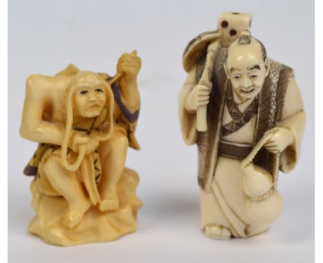 A Japanese Meiji period carved ivory netsuke modelled as an elderly gentleman carrying a double gourd with oversized dice on 
