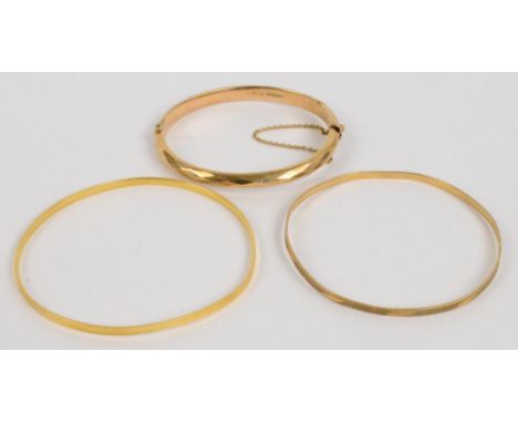 An 18ct yellow gold circular bangle, diameter 7.3cm, a further 9ct example, and a 9ct snap bangle with faceted decoration, ap