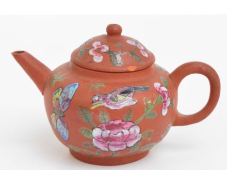 A late 19th century Chinese Yixing teapot of squat baluster form, painted in enamels with birds, butterflies and floral spray