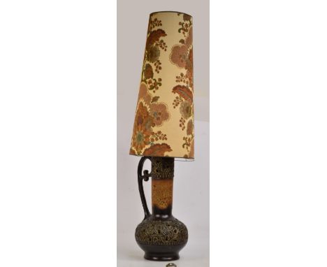 A large 1970s West German lamp in the form of a handled ewer, with pierced belied bottom, raised on circular foot and pierced
