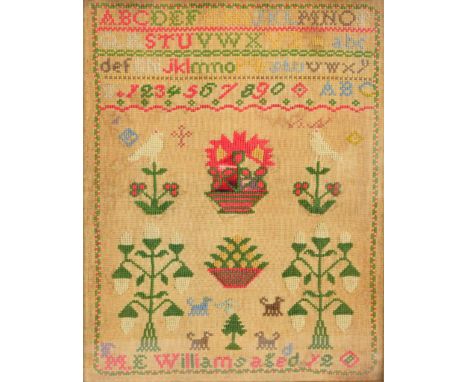 A woolwork alphabetical and numerical sampler with two baskets of flowers flanked by floral motifs, by ME Williams, aged 12, 