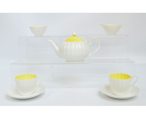 A Susie Cooper tea for two cream and yellow glazed tea service comprising teapot, two cups and saucers, jug and bowl, length 