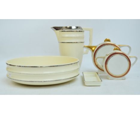 A French terre de fer (ironstone) Choisy Le Roi Art Deco style washing jug and bowl in cream with silver stripes, and a match