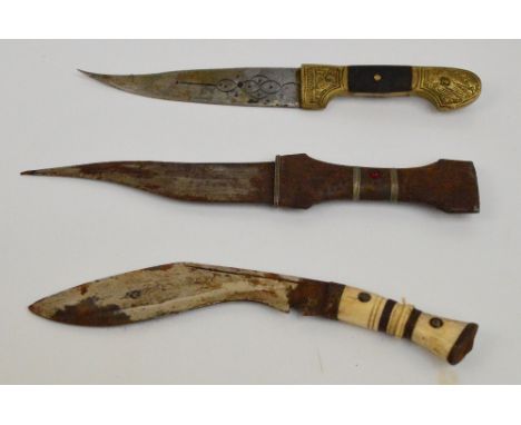 Three Eastern daggers to include a brass handled example with horn detail and with brass scabbard and a bone handled example 