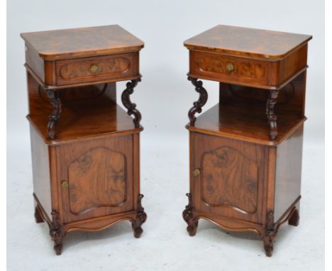 A pair of burr walnut bedside cabinets, the single frieze drawer above a shelf with C-scroll decorated supports and single cu