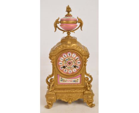 A late 19th century French gilt spelter and porcelain mounted mantel clock, the urn shaped finial above circular pink dial ab