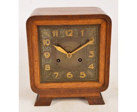 An Art Deco oak cased eight day mantel clock with square dial set with Arabic numerals inscribed "Ingersoll", height 24cm.