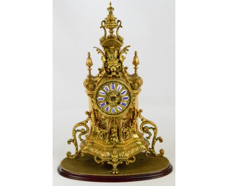 A 19th century French gilt metal mantel clock, the circular dial set with enamel hour markers with blue Roman numerals, the e