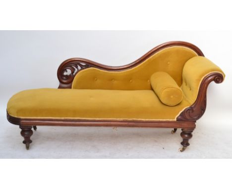 A Victorian mahogany chaise longue, the scrolling pierced back with button upholstery, padded seat and ring turned front legs