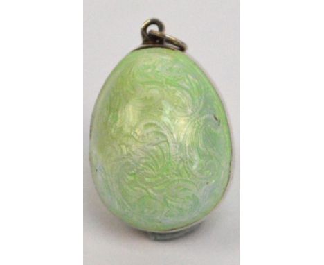 A late 19th century Russian white metal and green guilloche enamel decorated egg shaped locket pendant, bearing a spurious Fa