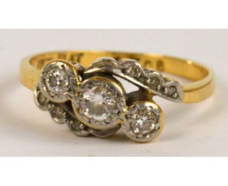 An 18ct yellow gold three stone diamond crossover ring, size M, approx 3.1g.