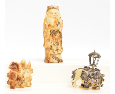 A Japanese Meiji period carved ivory figure group netsuke modelled as an elderly man with two women and with elders face to t
