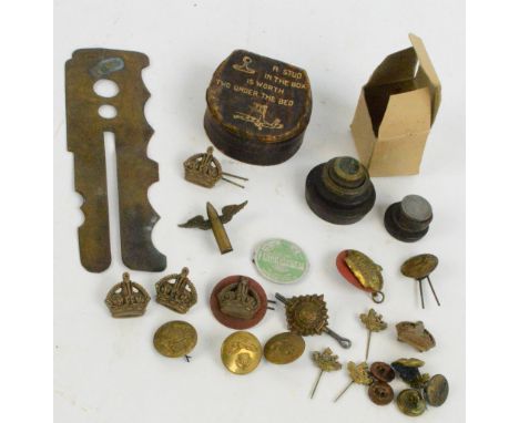 A group of various military related brass badges and buttons, a button polishing tool and a set of stacking weights.