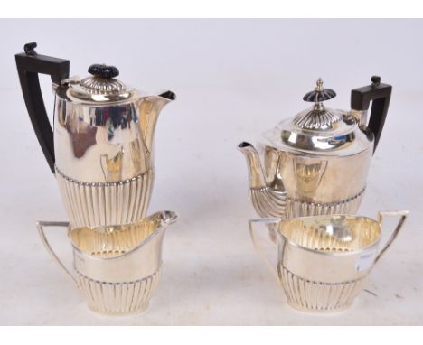 A George V hallmarked silver four piece tea set comprising teapot of oval form with gadrooned decoration to lower body, lengt