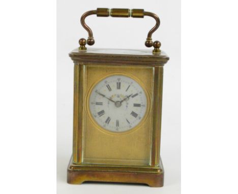 A 20th century French brass cased carriage clock, the engine turned decorated rectangular face with circular enamel dial set 