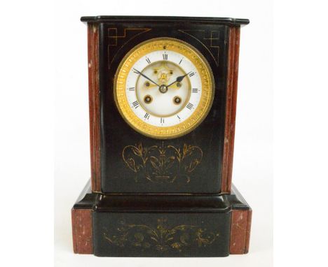A late Victorian black slate and red marble detailed eight day mantel clock, the circular enamel dial set with Roman numerals