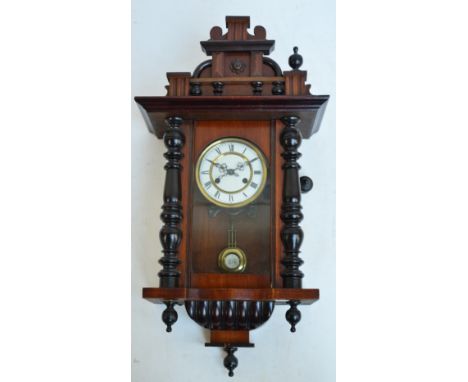 A small Vienna style eight day wall clock, the circular enamel dial set with Roman numerals with ornamental pediment and turn