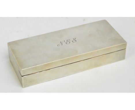 A George VI hallmarked silver cigarette box with engine turned decoration and central initials "NES", with adjustable interio