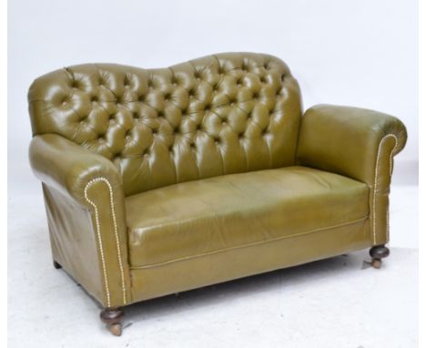 A c.1900 olive green button leather upholstered three piece lounge suite raised on bun feet.