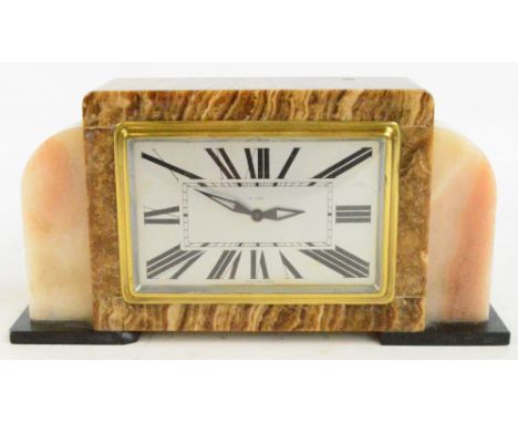 A French Art Deco brown onyx eight day mantel clock with rounded rectangular silvered dial set with Roman numerals, length 28