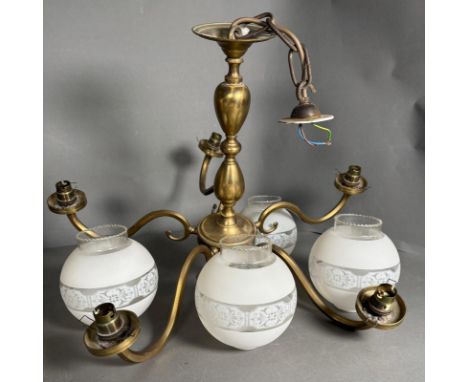 A brass five arm chandelier and four etched glass shades 