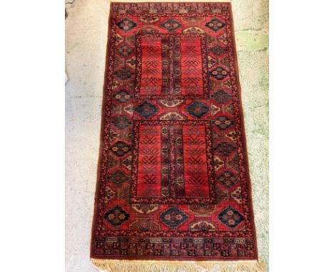 A wool runner, red grounds with geometric border 107cm x 85cm 