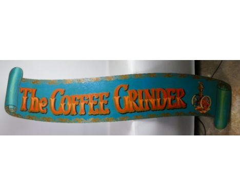 A shop's painted wooden advertising sign, in the form of a scrolling banner for "The Coffee Grinder" with orange and gilt let