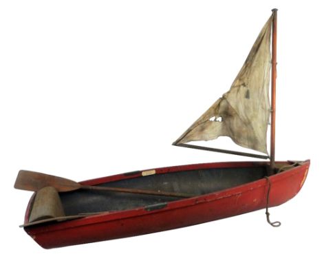 A Lines Bros. Ltd Merton Playboat, with red painted wooden hull, foremast with single sail, removable slatted wooden seat and