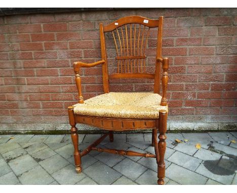 A rush seated light wood armchair
