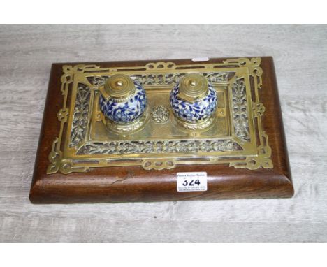Early 20th century brass inkstand with oak wood base, pierced brass fretwork with two ceramic and brass lidded rounded ink po